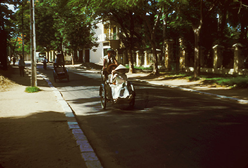 Một góc đường Đà Nẵng với nhiều cây cối rợp bóng mát, xe xích lô là phương tiện được sử dụng phổ biến. Những năm đầu thập niên 50 cũng là thời điểm Pháp rút khỏi Đà Nẵng.